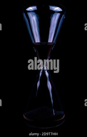 glass hourglass time concept on a black backdrop. Countdown timing concept simple Stock Photo