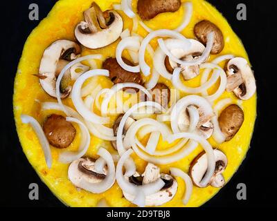 Omelette with onions and mushrooms in frying pan Stock Photo