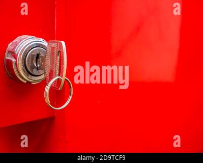Key in the keyhole on a red background. Stock Photo