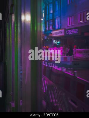 Neon light fluorescent colors blue green and purple being reflected in a bar window Stock Photo