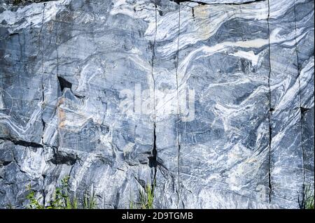 Rock cut raw surface of white and grey marble in the natural environment. Blue marble career texture. Real stone, industrial material for buildings and interior. Abstract background pattern Stock Photo