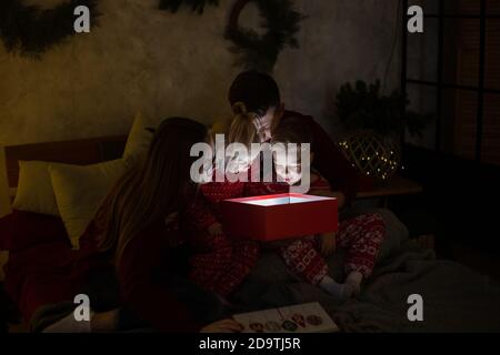 Excited family opening gift box on Christmas night Stock Photo