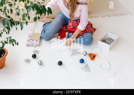 Woman decorating christmas present. Preparing for the Christmas holidays. Stock Photo
