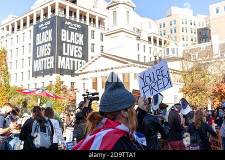 Washington, DC, USA 11/06/2020: Crowd gathered in Black Lives Matter Plaza near White house celebrate the results of US elections. A woman is holding Stock Photo