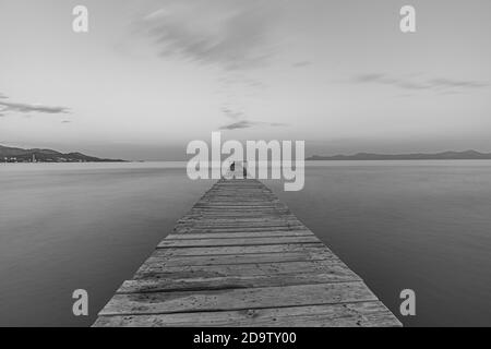 Image of one of the walkways of Muro beach, in black & white, one of the best known and most famous in Mallorca, in the Balearic Islands, at sunset. Stock Photo