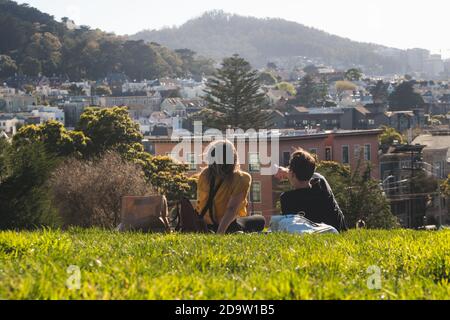 San Francisco, California, USA - MARCH 15 2019: People having a picnic in Alamo Square Park on a sunny day with blue skies