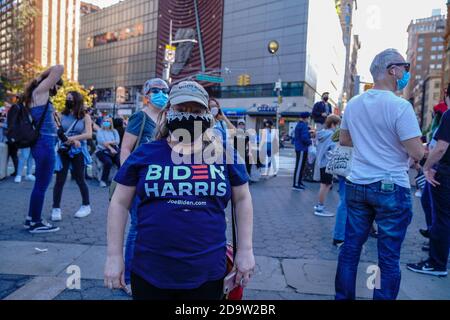 A woman wearing a mask and  Biden-Harris shirt seen during the celebration of Biden’s win as the 46th U.S President at Union Square in New York. Stock Photo