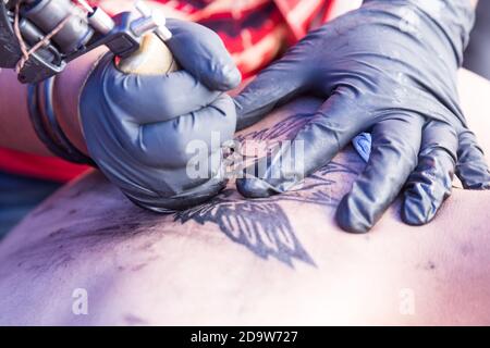 Closeup of tattoo grafting drawing onto body using tools Stock Photo