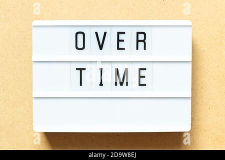 Lightbox with word overtime on wood background Stock Photo