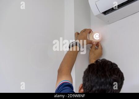 Technicians are installing a CCTV camera on the wall, can connect to the Internet, and control the camera via a smart phone or tablet. Stock Photo