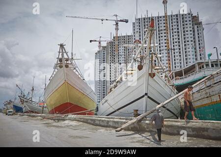 Jakarta, Indonesia, March 2016. Sailors working on the traditional wooden boats, the Pinisi, in the port of Sunda Kelapa. Stock Photo