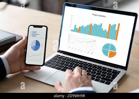 Close up young businessman using modern gadgets, working on project. Stock Photo