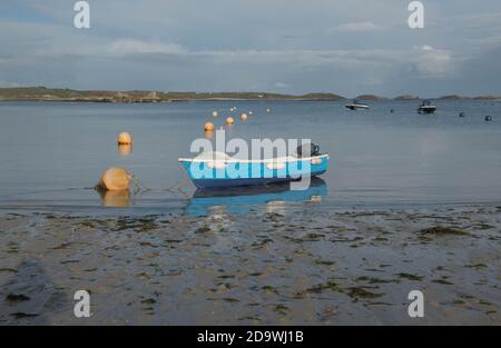 Blue Boat Moored in the Evening Sunlight on Old Grimsby Beach on the Island to Tresco in the Isles of Scilly, England, UK Stock Photo