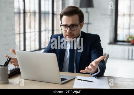 Displeased stressed young 30s businessman looking at computer screen. Stock Photo