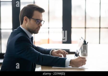 Skilled ceo manager checking financial documentation in office. Stock Photo