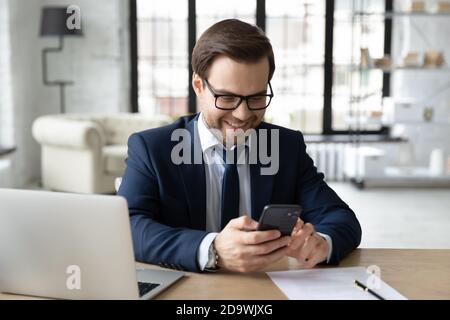 Smiling young male ceo executive manager using smartphone. Stock Photo