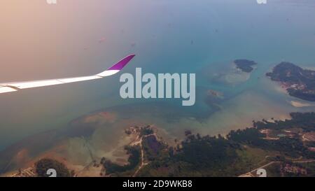 View from the window of the plane before landing, overlooking the sea and the beautiful island. Stock Photo