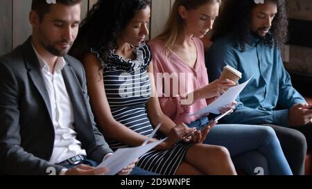 Diverse group of students sitting at hall preparing to exam Stock Photo