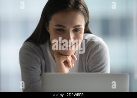 Happy smiling young woman reading good news from pc screen Stock Photo