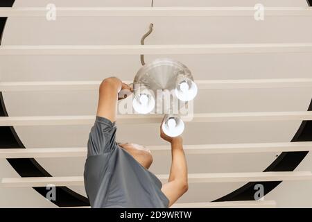 Electrical engineers are installing ceiling lamps in the hallway. Stock Photo