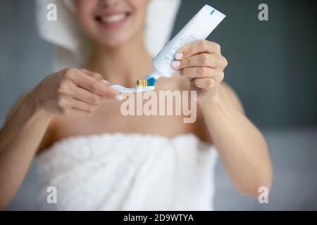 Smiling young female standing at bathroom preparing to clean teeth Stock Photo