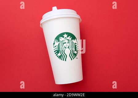 BERLIN - NOV 8: Starbucks Paper Cup. Starbucks Coffee with Logo Mermaid isolated on red background in Berlin on November 8. 2020 in Germany Stock Photo