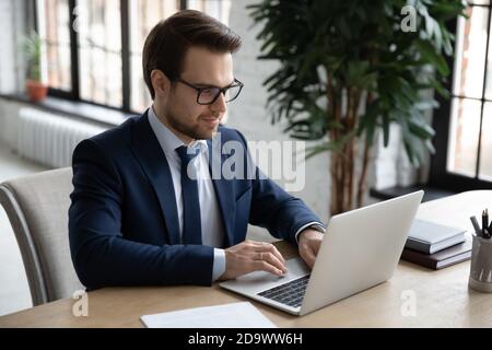 Smiling young businessman working on project online. Stock Photo