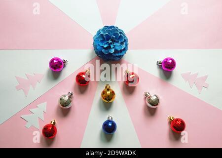 Bright Christmas balls and blue pine cone on  paper background. Flat lay, copy space Stock Photo