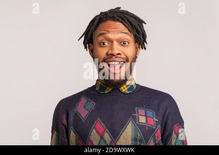 Extremely surprised shocked african bearded man with dreadlocks looking at camera with open mouth and big eyes, happy satisfied with sudden victory. I Stock Photo