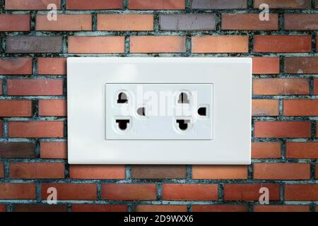 AC power plug on the vintage brick wall. Stock Photo