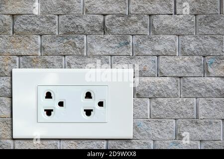 AC power plug on the vintage brick wall. Stock Photo