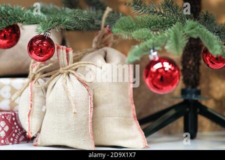 Wrapped gifts under the Christmas tree. Canvas bags, surprise gifts for children Stock Photo