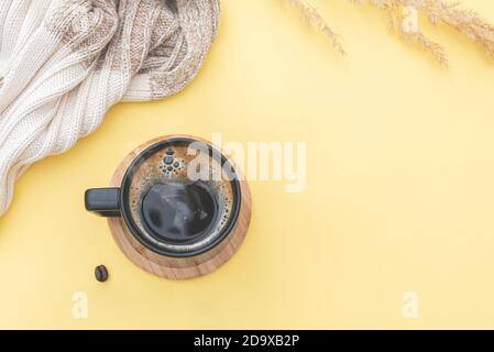 Morning composition: scarf on table with coffee mug, coffee beans. layout with space for text and ideas. Autumn season Stock Photo