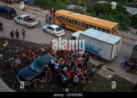 Recently displaced people in the wake of Hurricane Eta surround a truck giving out food in San Pedro Sula Honduras. In the aftermath of Hurricane Eta, hundreds of thousands of people have been displaced due to flooding. Stock Photo