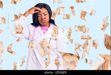 Young african american woman wearing doctor stethoscope worried and stressed about a problem with hand on forehead, nervous and anxious for crisis Stock Photo