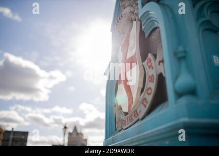 Lamp with the London Coat of Arms from the Tower Bridge overshadowing the sun Stock Photo