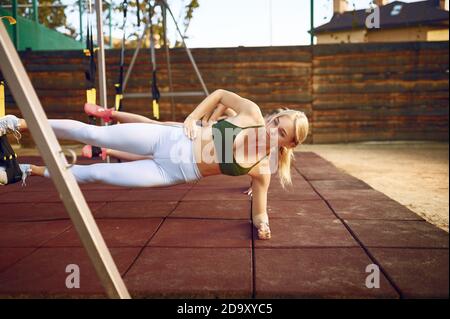 Women's group doing abs exercise outdoors Stock Photo