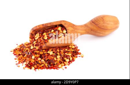 Chili and paprika in wooden scoop, isolated on white background. Mix of hot and sweet red pepper with grains. Stock Photo