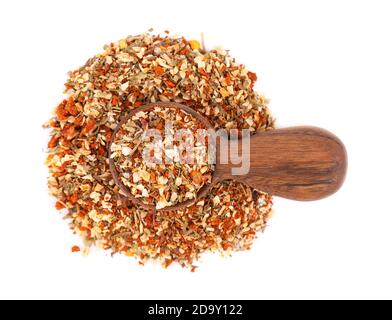 Mix of herbs, spices and dry tomatoes in wooden spoon, isolated on white background. Natural organic food seasoning. Top view. Stock Photo