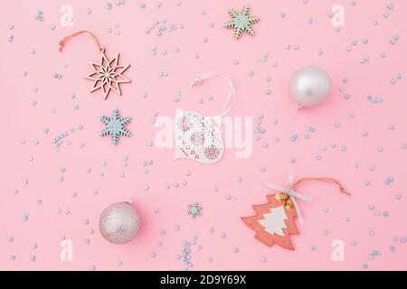 Christmas composition made of silver decoration and confetti on pink background. Flat lay, top view. Stock Photo