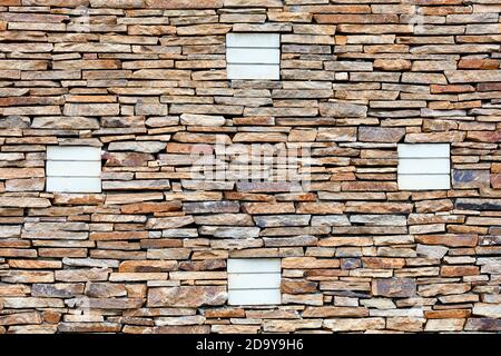 Part of a sandstone stone wall with silicate brick ornaments, expressive texture and background in high resolution. Stock Photo