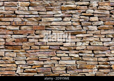 Part of a sandstone stone wall, expressive texture and background in high resolution. Stock Photo