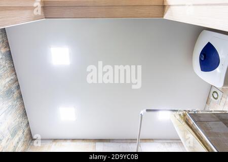 Stretch matte ceiling in the bathroom with three square lamps Stock Photo