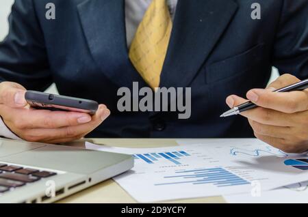 Financial business man document graph analyzing and checking income-expenses. Business concept of tax and finance. Stock Photo
