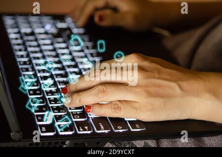 female hands using keyboard computer laptop with flying shopping online icons. Stock Photo