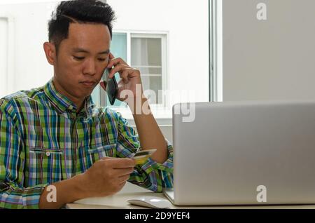 man talking on the phone finance credit card information. Concept of tax and finance Stock Photo