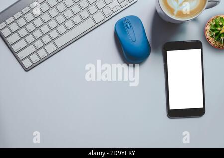 Top view mockup smartphone  , keyboard, coffee mug and cactus on background.copy space Stock Photo