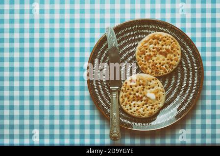 Old Formica table with crumpets on a plate Stock Photo
