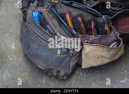 rugged and torn leather bag of a cobbler containing shoe polish brush and tools. close up shot. Stock Photo