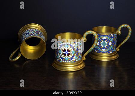 Old fashioned glass holders of brass with color enamel pattern, vintage utensil of russian soviet period Stock Photo